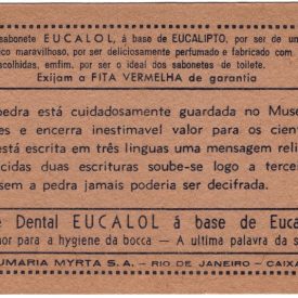 Verso da estampa Eucalol sobre a Pedra de Rosetta onde se lê propagandas dos produtos Eucalol e o texto principal: "Esta pedra está cuidadosamente guardada no Museu de Londres e encerra inestimável valor para os cientistas. Nela está escrita em três línguas uma mensagem religiosa. Conhecidas duas escrituras soube-se logo a terceira, a qual, sem a pedra jamais poderia ser decifrada."